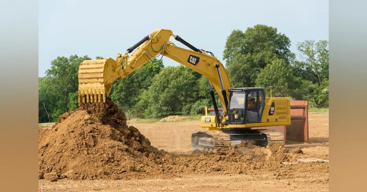 Excavators parked in a yard at sunset